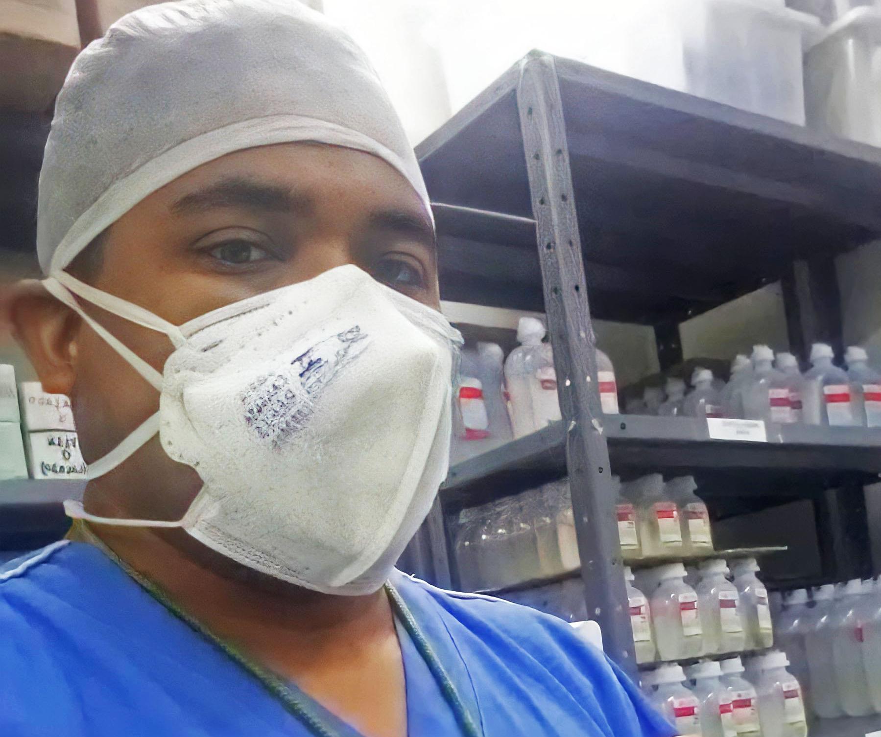 José Lino, farmacêutico e maqueiro, posa em frente a prateleiras de medicamentos