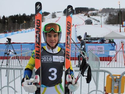 Michel Macedo sorri para foto em alto de monte com neve durante competição