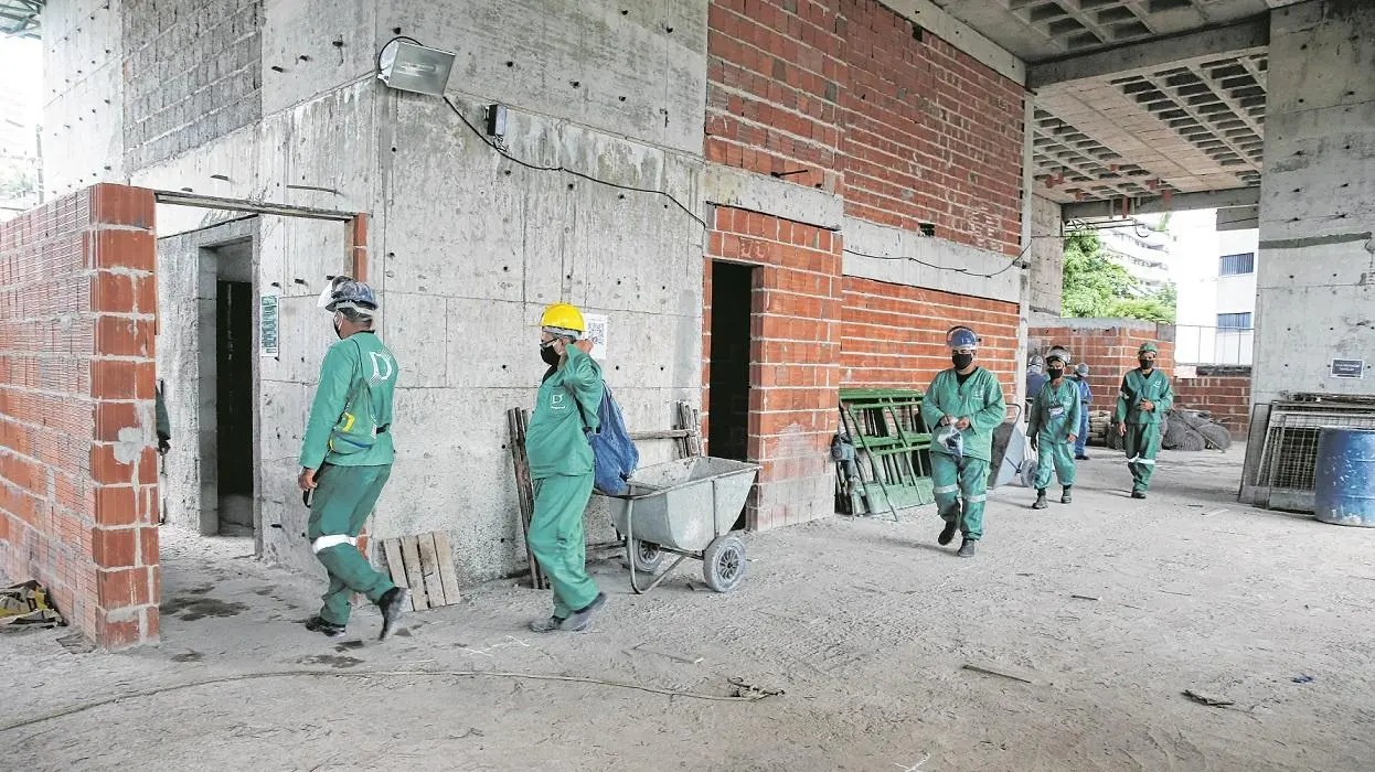Trabalhadores em obra usam máscaras