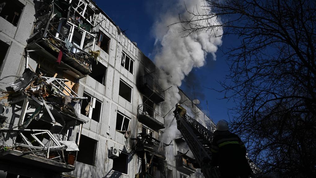 Bombeiros trabalham em um incêndio em um prédio após bombardeios na cidade de Chuguiv, no leste da Ucrânia, em 24 de fevereiro de 2022
