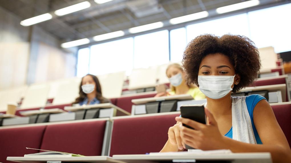 Estudante usando máscara médica protetora facial para proteção contra doenças virais em uma sala de aula