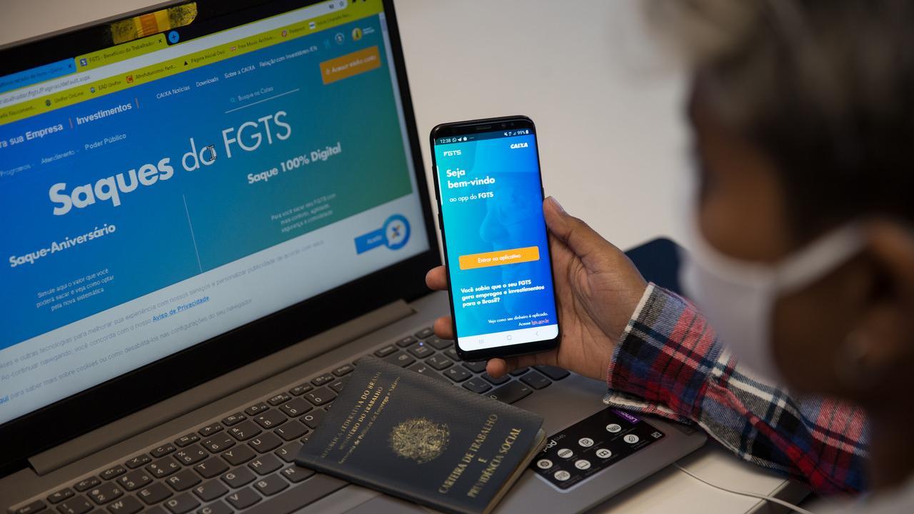 Close nas mãos de trabalhador que usa o Aplicativo do FGTS