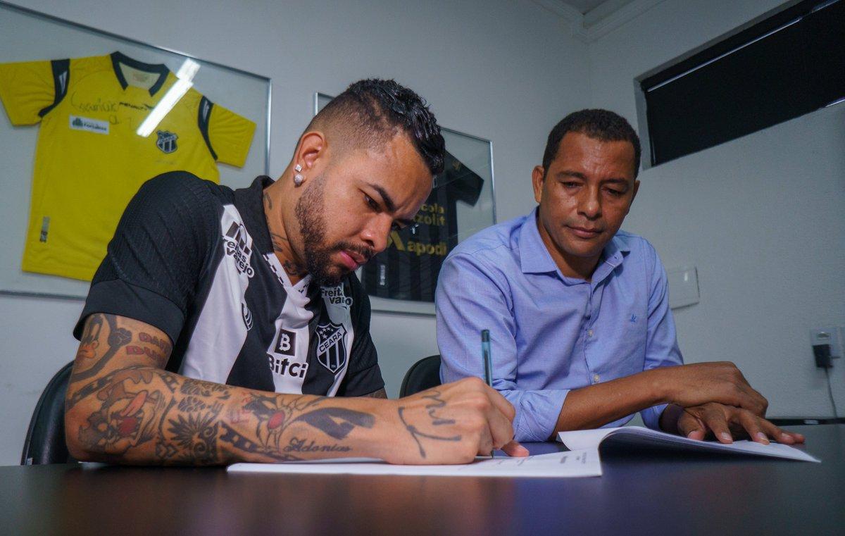Dentinho assinando contrato com Gilberto Silva ao lado