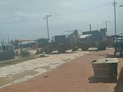 Tratores sobre calçadão na Comunidade do Poço da Draga, na Praia de Iracema, antes de barracas serem destruídas