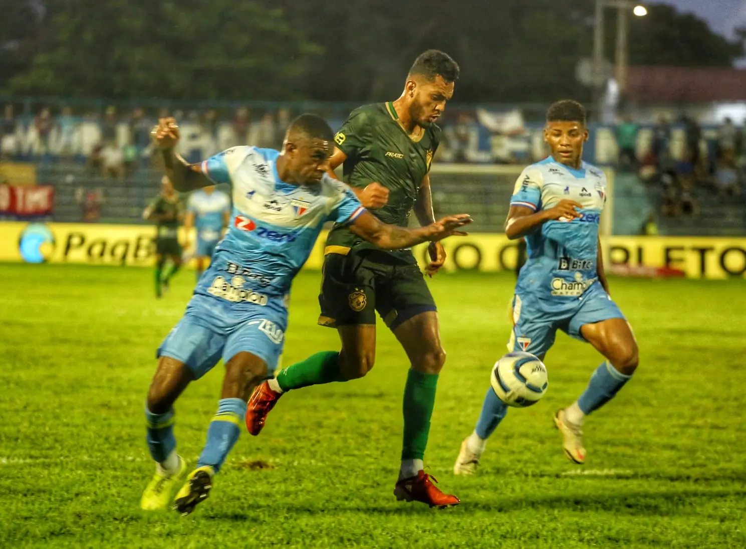 Imagem mostra jogadores disputando a bola.