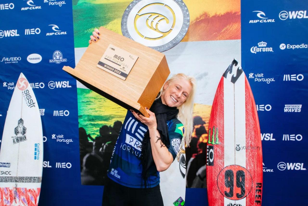 Tatiana Weston-Webb sorri e levanta troféu de vencedora no surfe