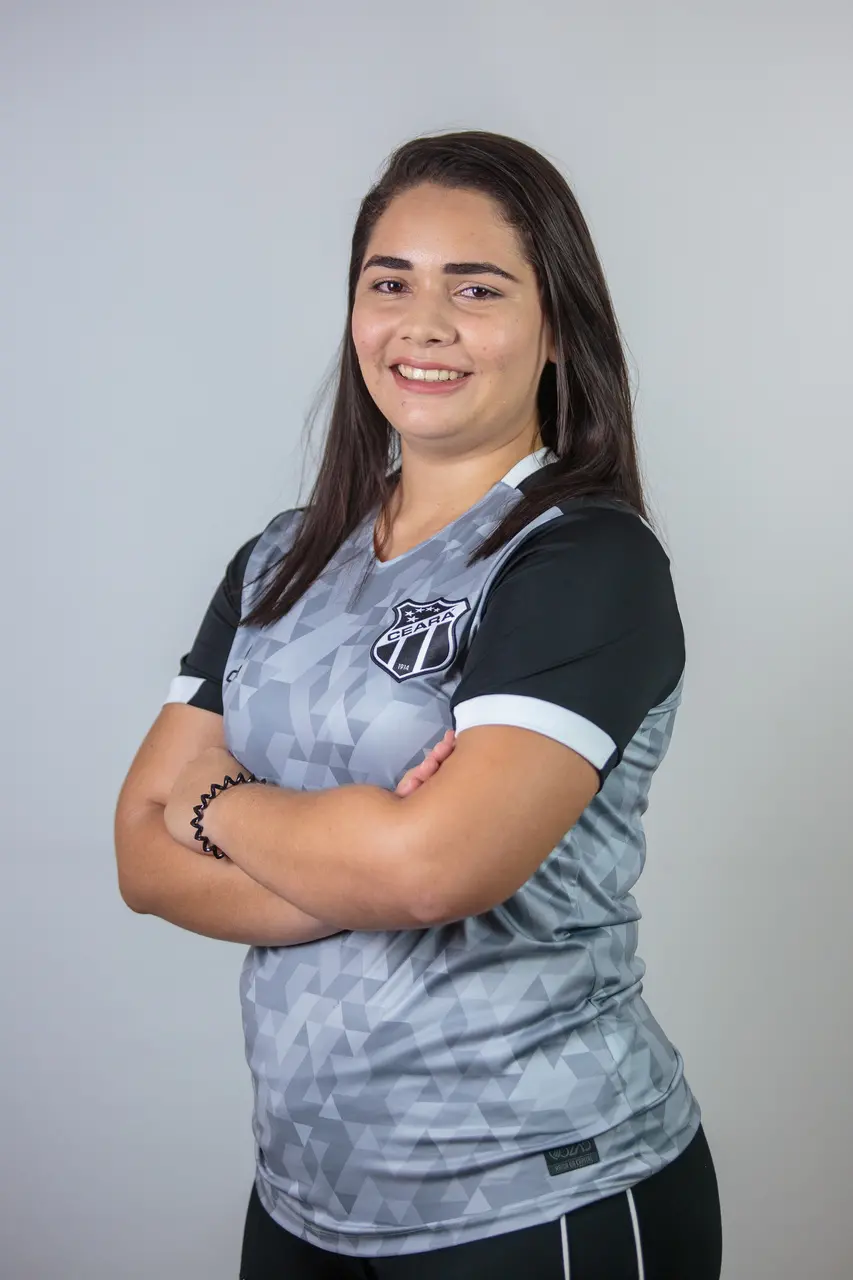 Imagem mostra mulher de braços cruzados e sorrindo.