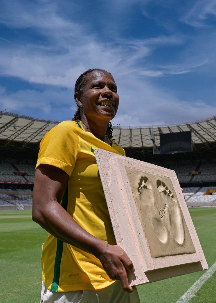 Imagem mostra mulher segurando placa com formato dos pés