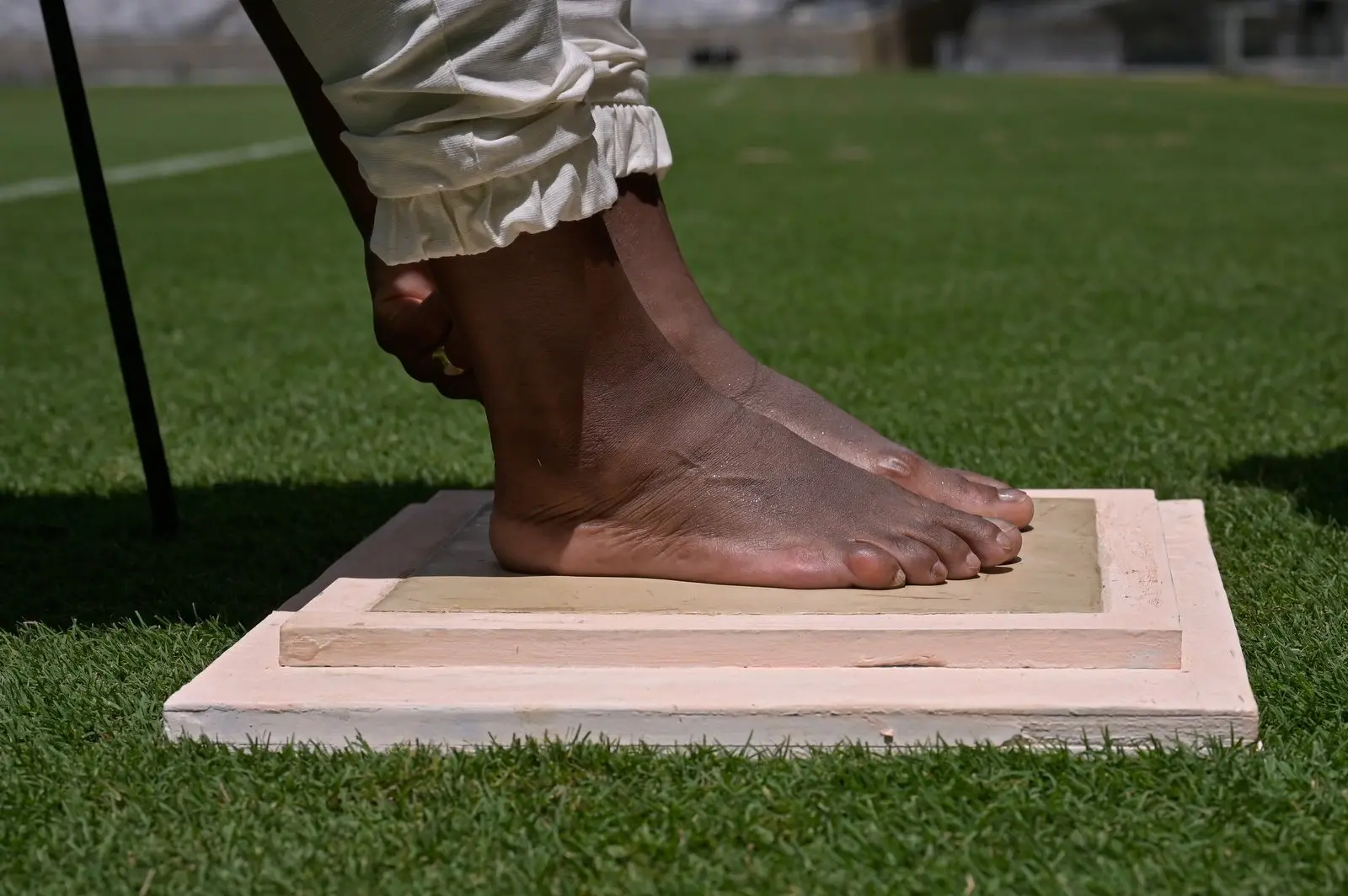 Imagem mostra dois pés numa placa de gesso.