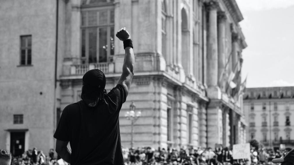 Homem ergue punho diante de manifestação