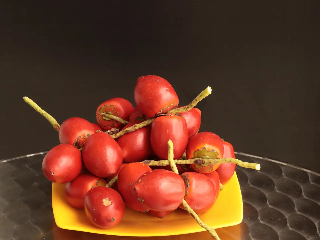 Furtos de pupunha em um prato amarelo sobre um fundo escuro