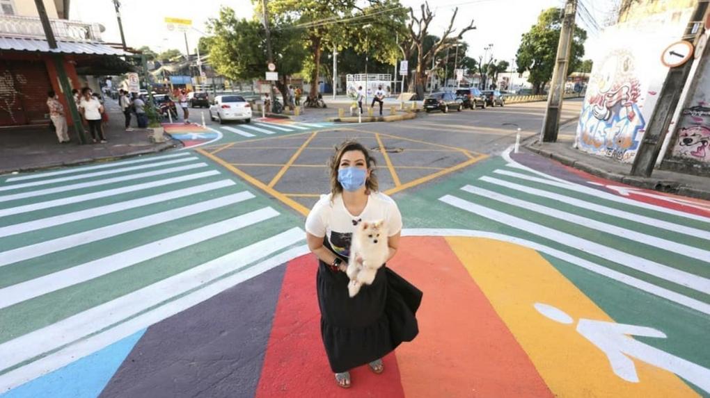 A ex-primeira-dama de Fortaleza Natália Herculano está no cruzamento de avenidas da Capital segurando a cadela Marrion.