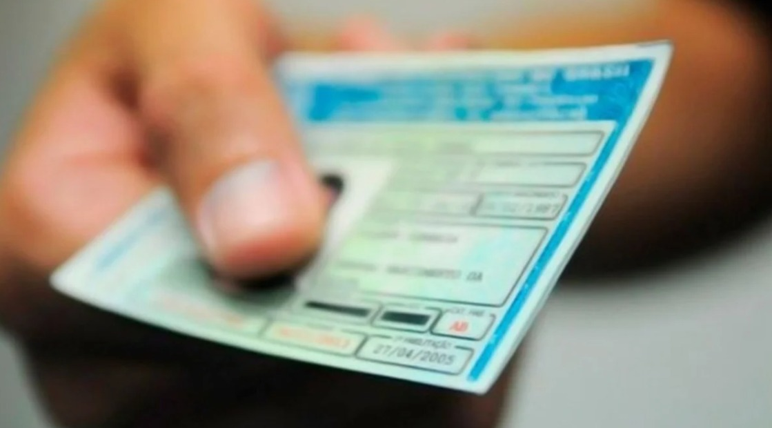 Pessoa segura uma carteira de habilitação nacional