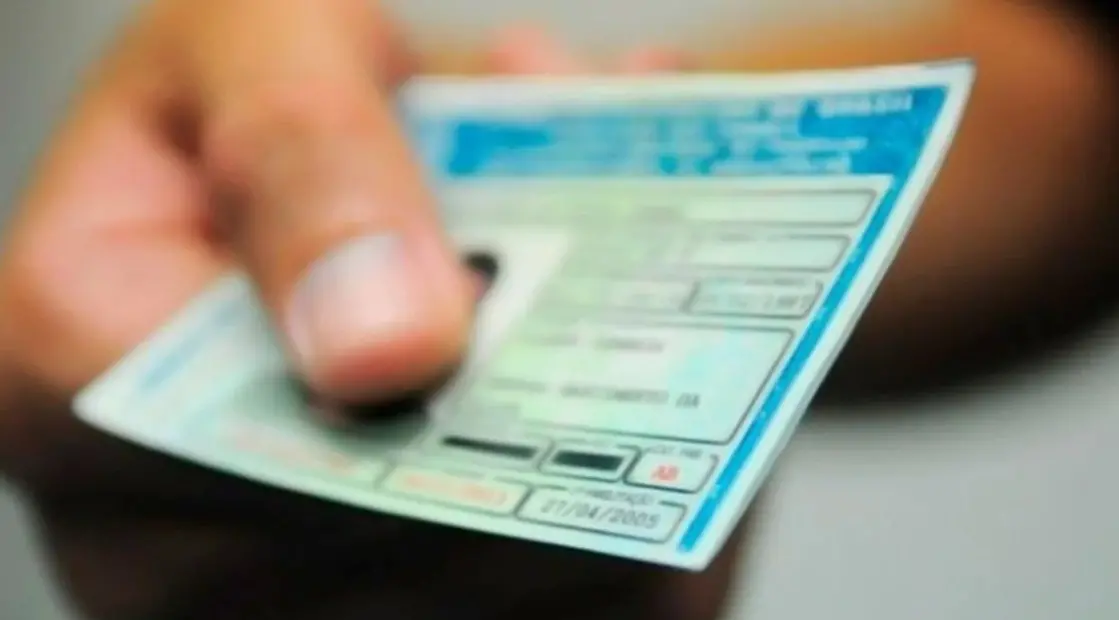 Pessoa segura uma carteira de habilitação nacional