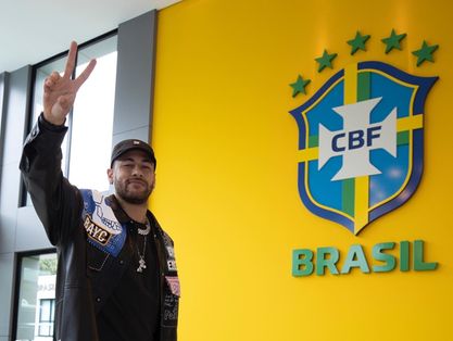 Neymar posa para foto ao lado do escudo da CBF