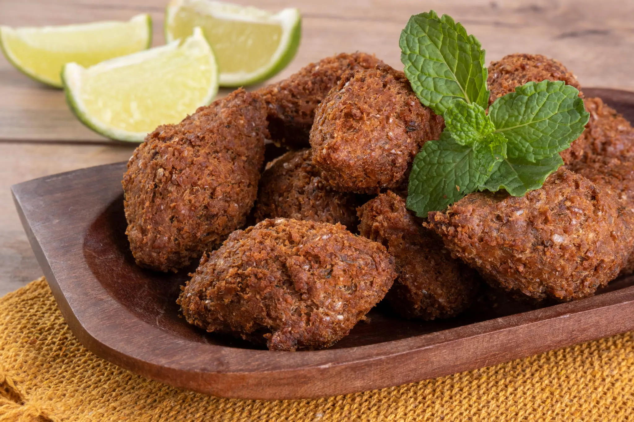 Quibes em um recipiente ao lado de um limão partido