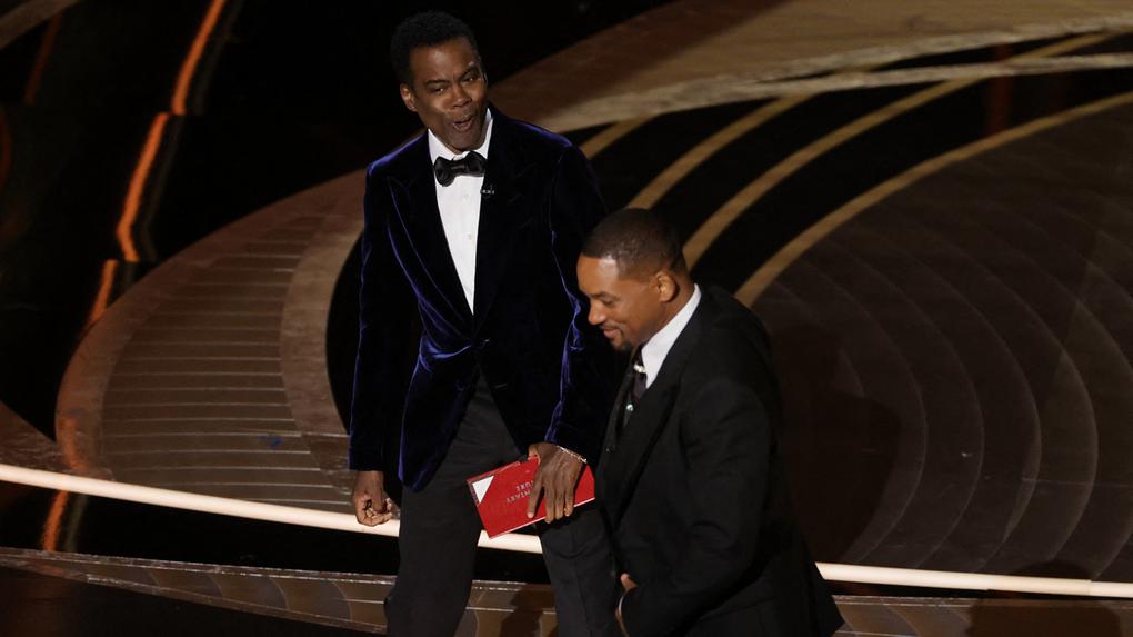 Chris Rock e Will Smith são vistos no palco durante o Oscar 2022