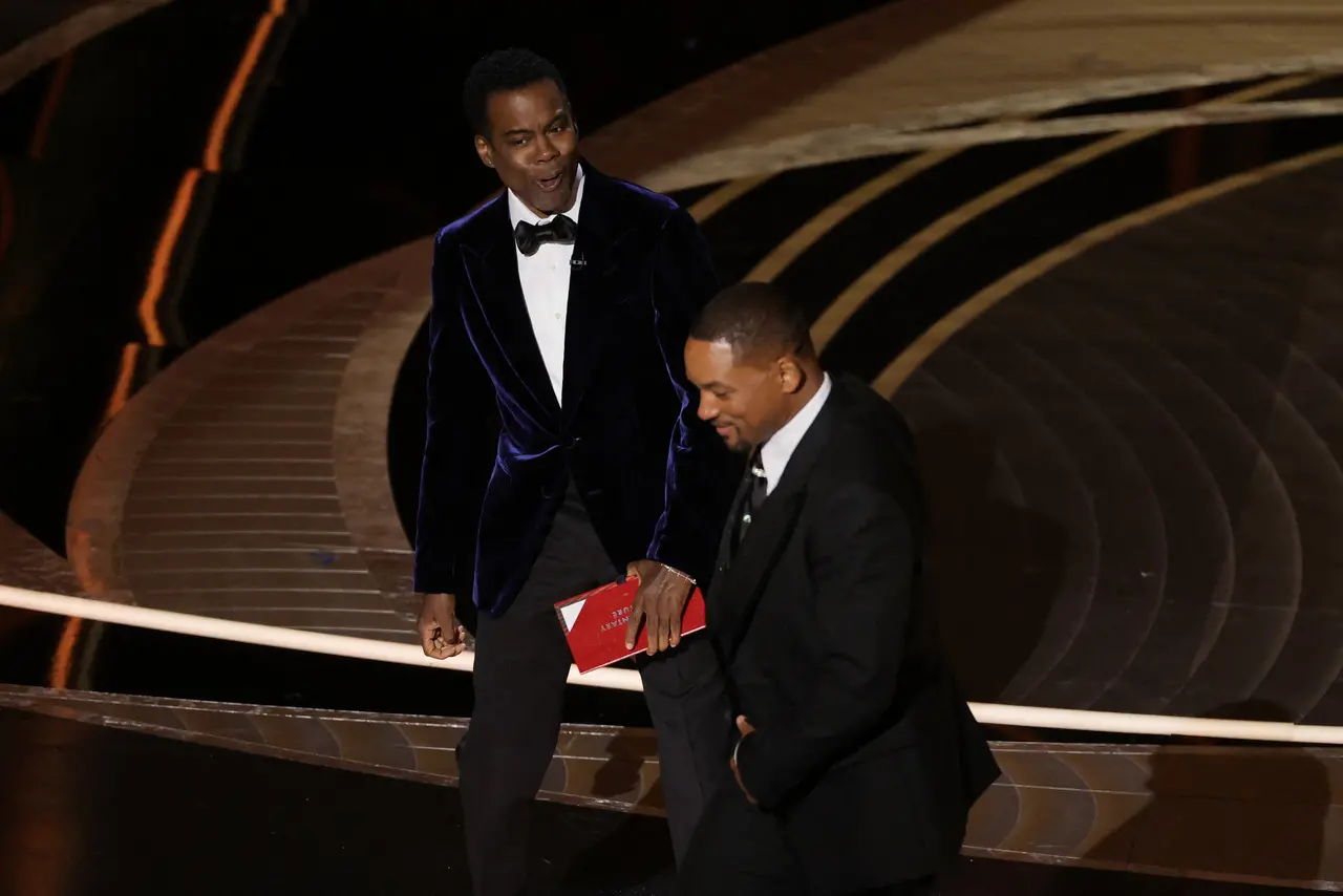 Chris Rock e Will Smith são vistos no palco durante o Oscar 2022
