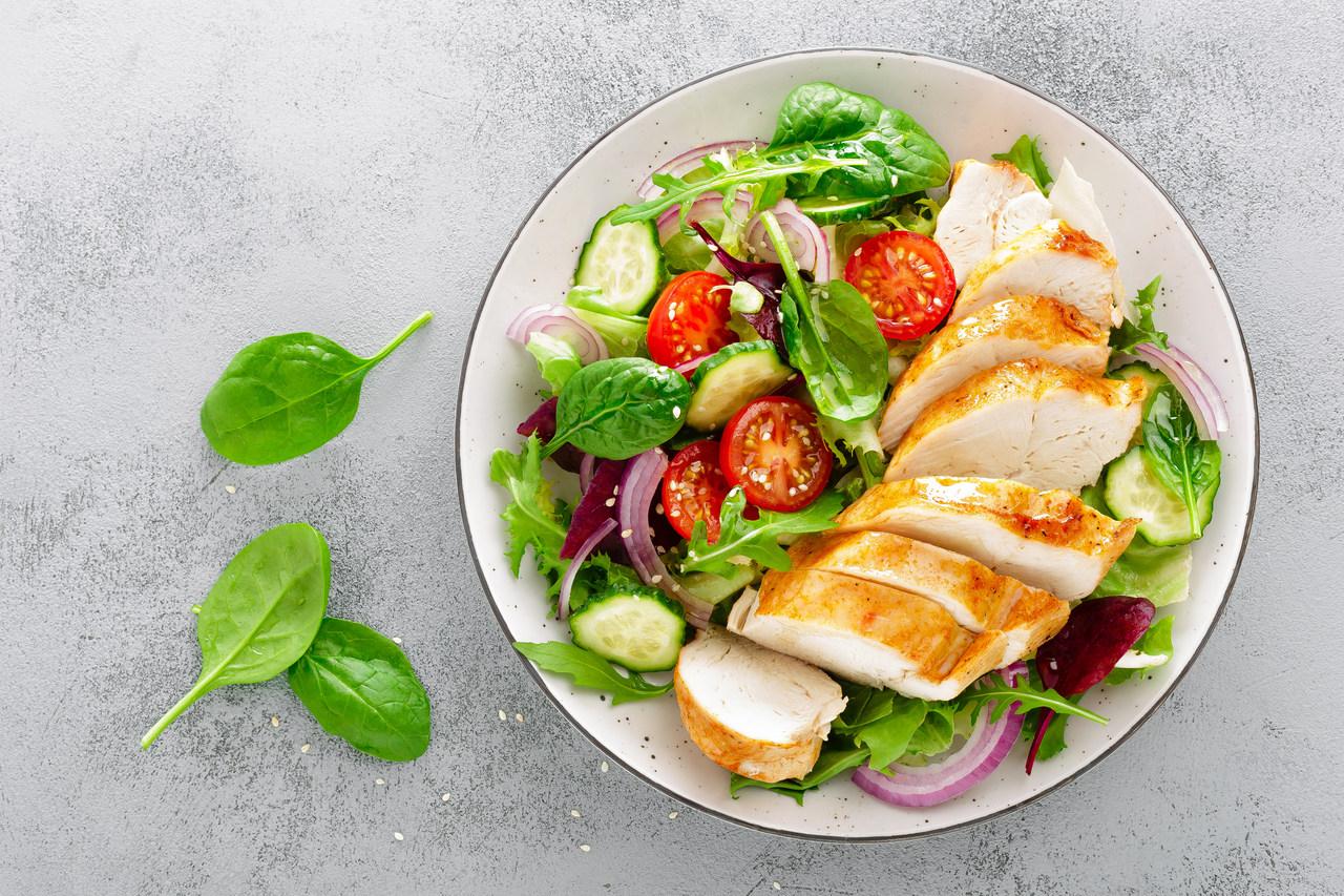 Salada com frango sobre um fundo claro