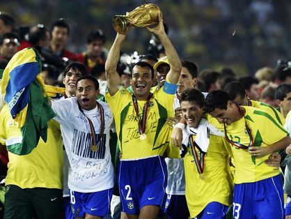 Atletas da Seleção Brasileira carregam a taça de campeão da Copa do Mundo