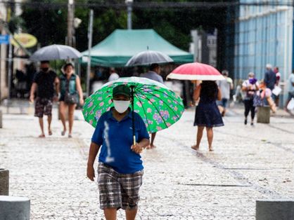 Homem caminha na Praça do Ferreira, em Fortaleza, sob chuva