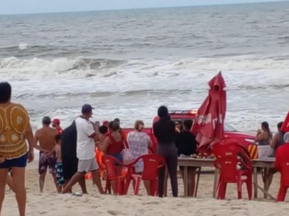Pessoas se aglomeram na praia da Sabiaguaba para ver resgate de vítima de afogamento.