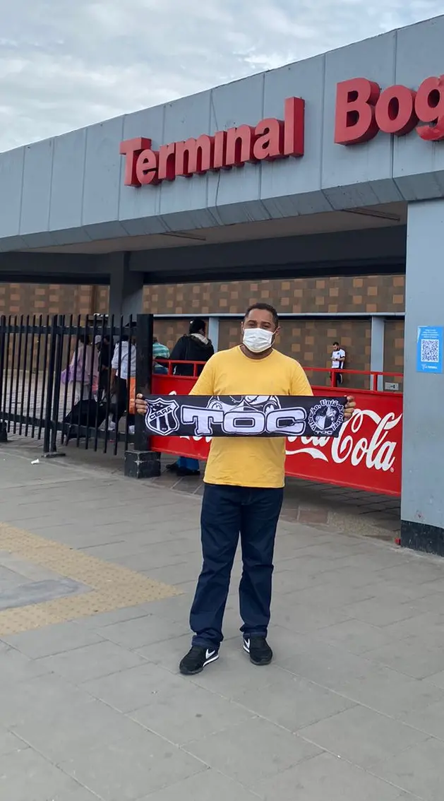 Imagem mostra homem em frente a terminal de ônibus