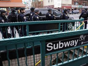 Membros do Departamento de Polícia de Nova York patrulham as ruas depois que pessoas ficaram feridas durante um tiroteio na hora do rush em uma estação de metrô no bairro de Brooklyn, em Nova York, em 12 de abril de 2022