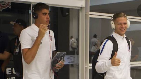 Atletas do Corinthians sorriem para foto durante chegada em hotel