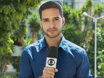 Jornalista Gabriel Luiz com microfone e canopla da Globo