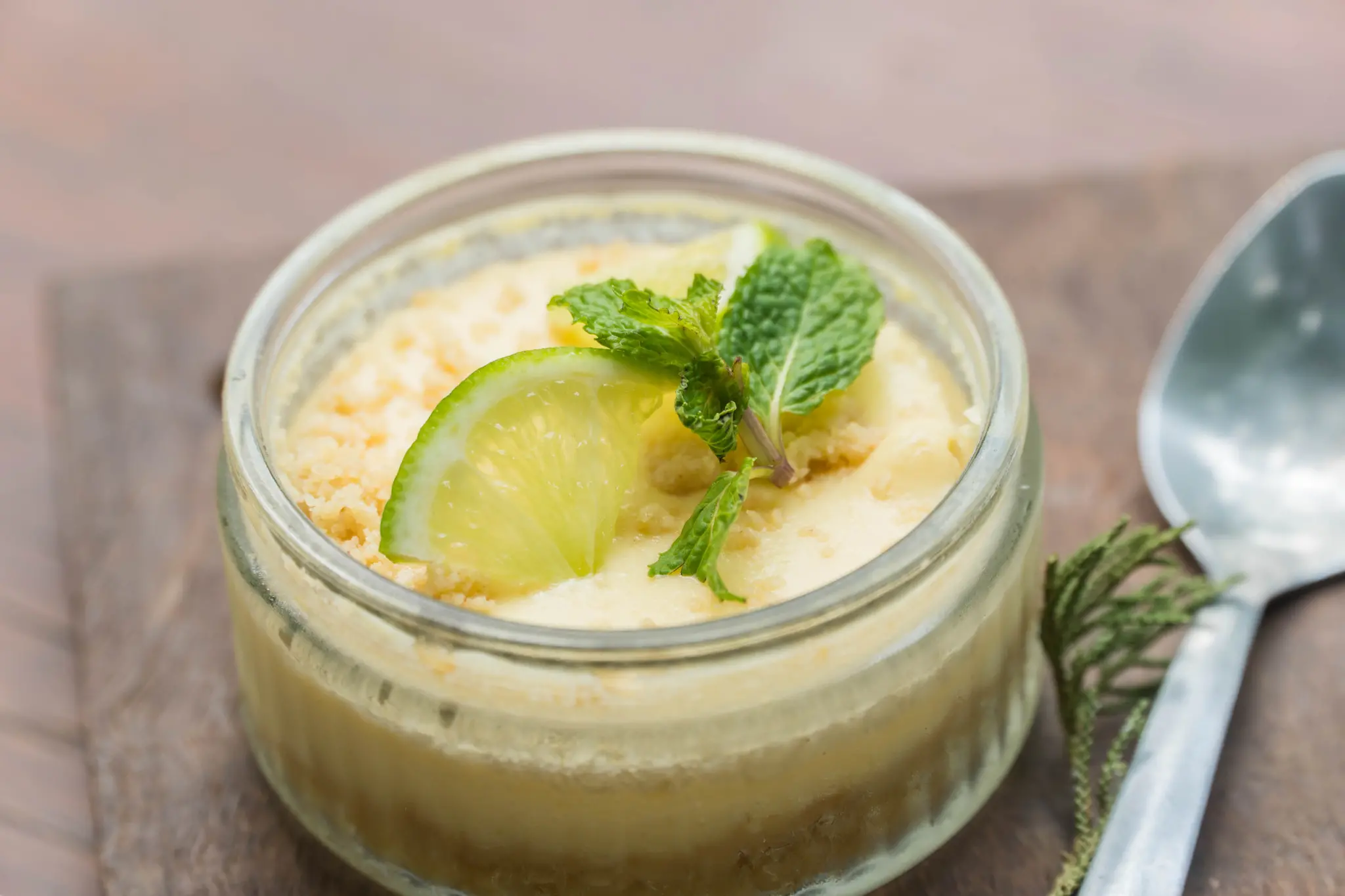 Pavê de limão em um recipiente de vidro ao lado de uma colher