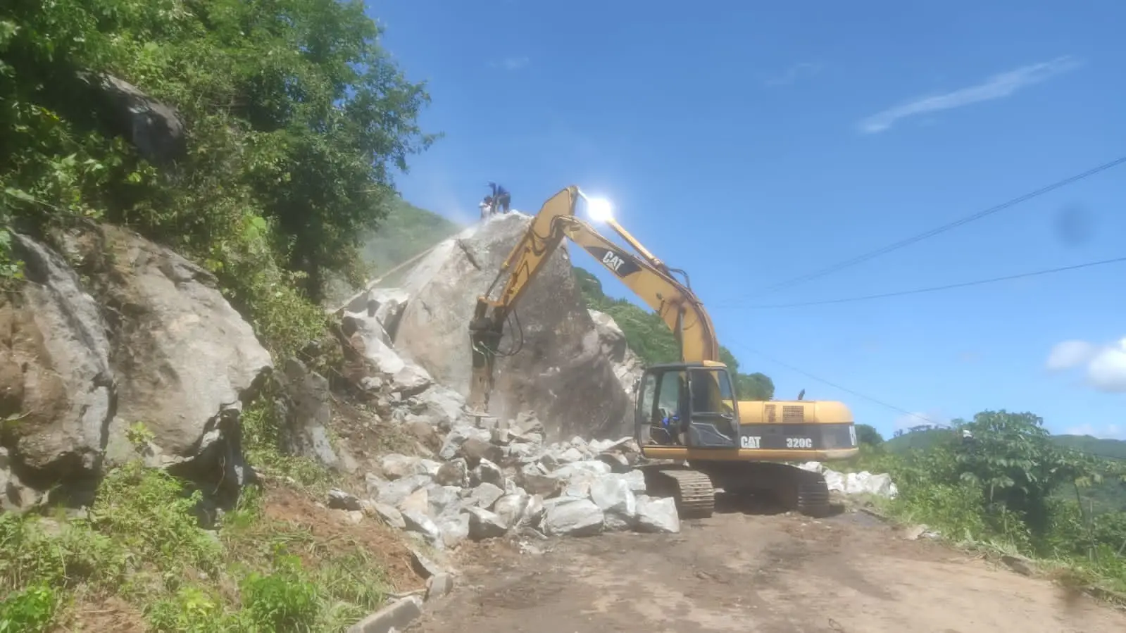 Trabalho de retirada da rocha para desbloquear via interditada.