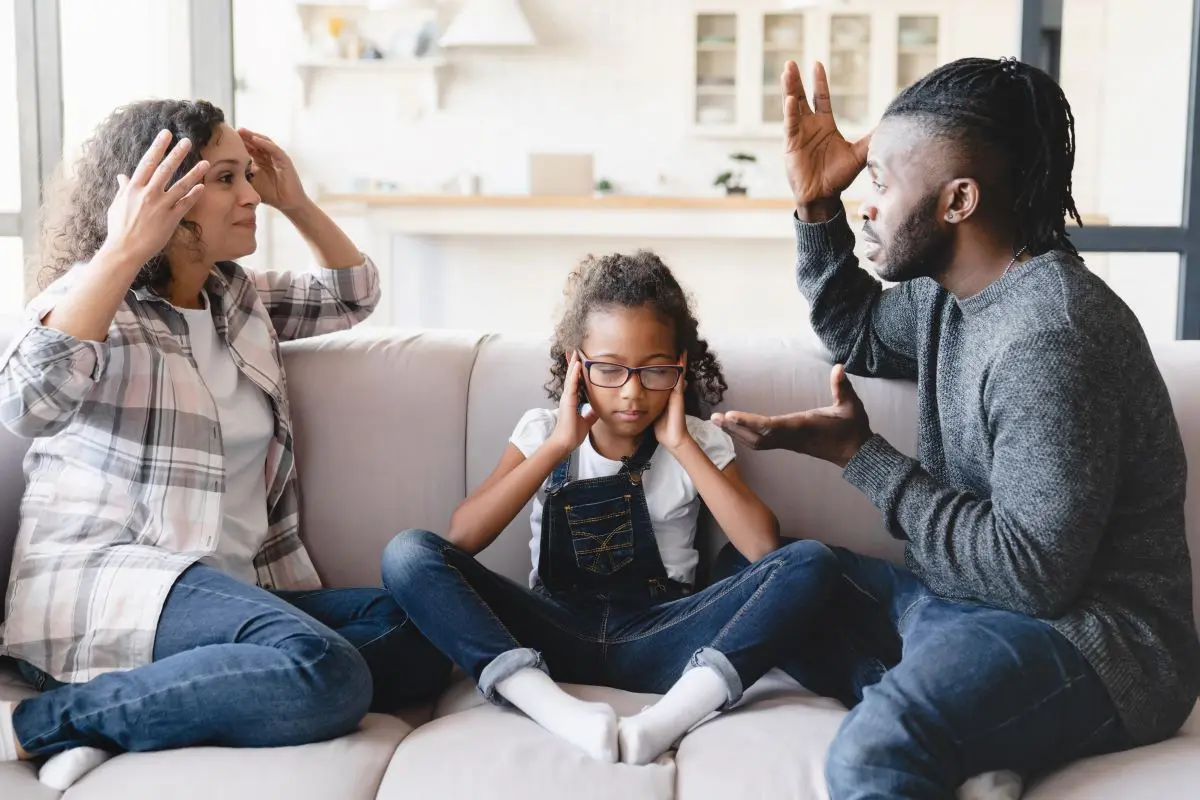 criança no meio de dois pais brigando, o que pode resultar em alienação parental