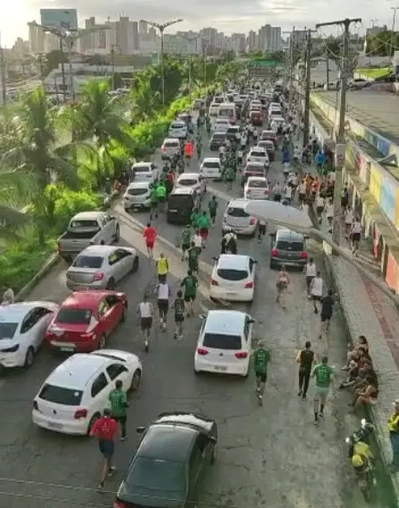 Imagem mostra pessoas correndo em meio aos carros
