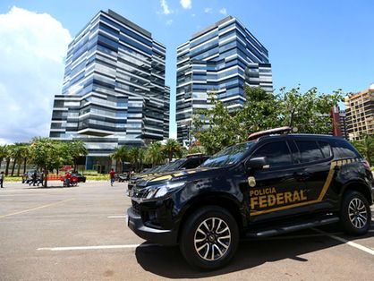 Em primeiro plano, uma viatura da Polícia Federal. Em segundo plano, a sede do órgão em Brasília.
