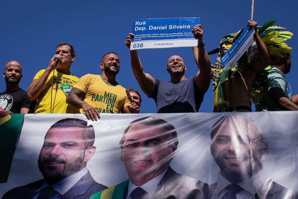 Ao lado de apoiadores, Daniel Silveira ergue placa de rua com seu nome em manifestação em Niterói.