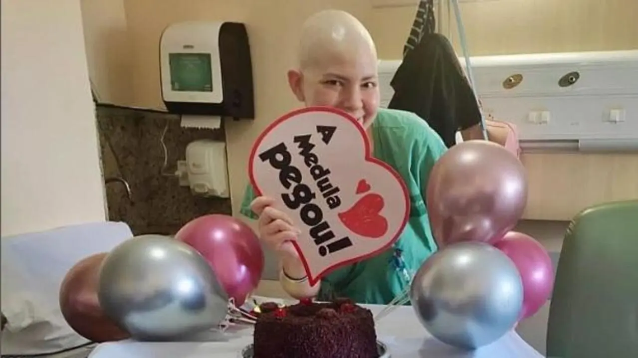 Repórter Marina Alves segurando placa com a frase 