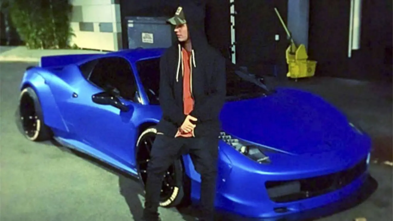 justin bieber sentado em ferrari azul