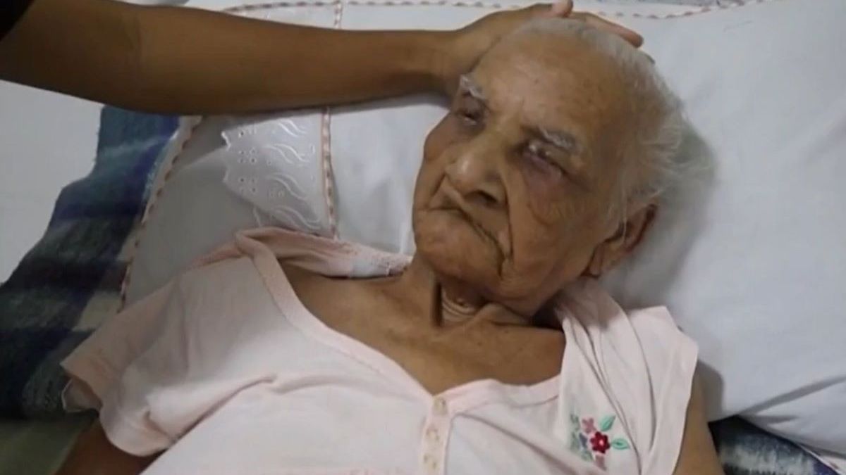 foto de maria gomes, idosa de 121 anos deitada em uma cama