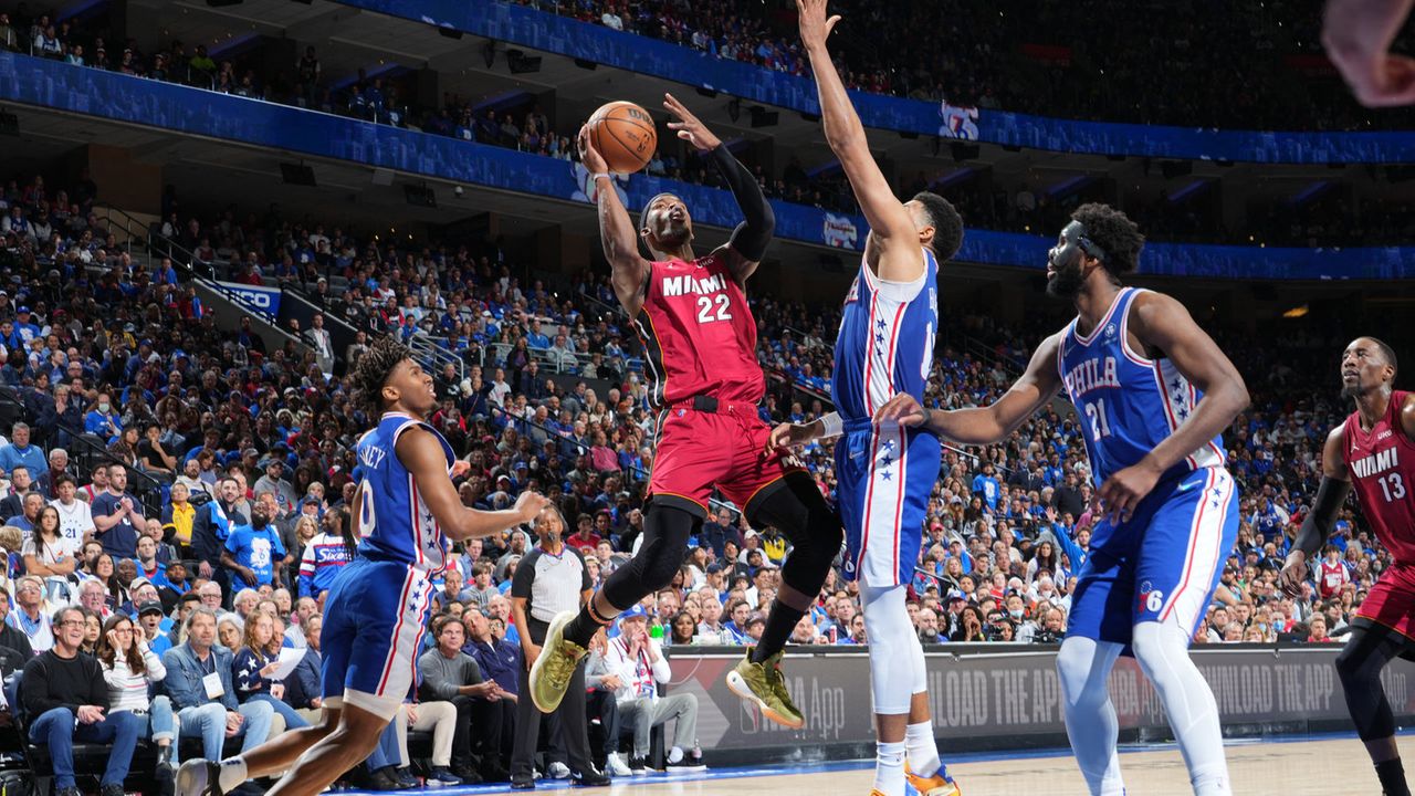 Atletas de Philadelphia 76ers e Miami Heat disputam a bola em jogo de basquete