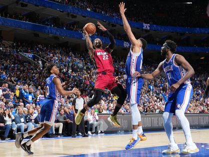 Atletas de Philadelphia 76ers e Miami Heat disputam a bola em jogo de basquete