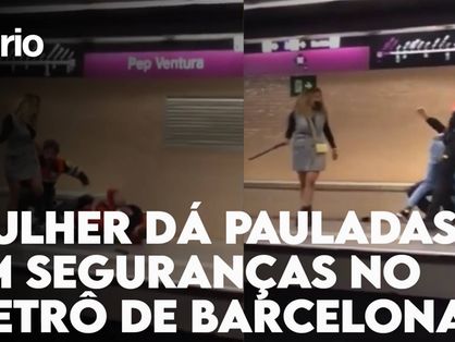 Imagem de vídeo com mulher agredindo seguranças no metrô de Barcelona com letrei escrito 