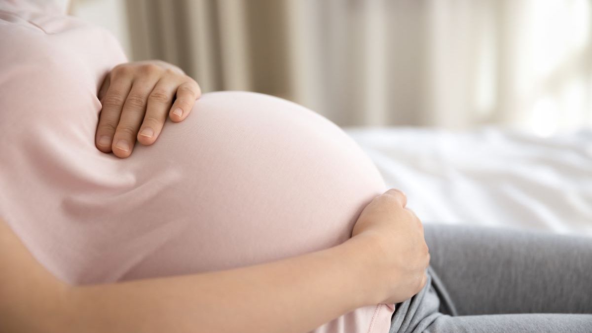 mulher grávida segurando barriga