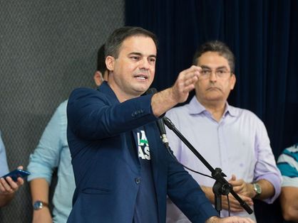 O pré-candidato ao Governo do Ceará, Capitão Wagner, discursando. Ele está de terno azul e, por baixo, uma camiseta com a logo do partido União Brasil. Apoiadores estão ao seu lado.