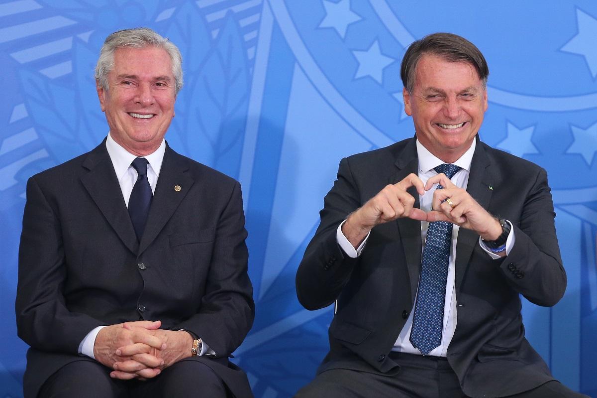 O ex-presidente Fernando Collor e o atual presidente Jair Bolsonaro. Bolsonaro está fazendo um coração com as mãos e Collor está sorrindo.