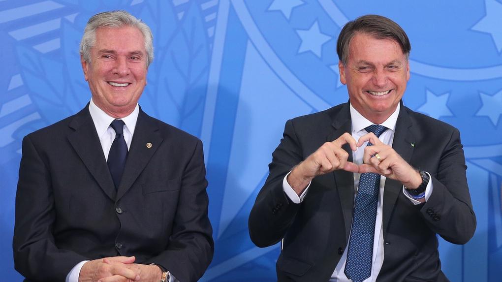 O ex-presidente Fernando Collor e o atual presidente Jair Bolsonaro. Bolsonaro está fazendo um coração com as mãos e Collor está sorrindo.