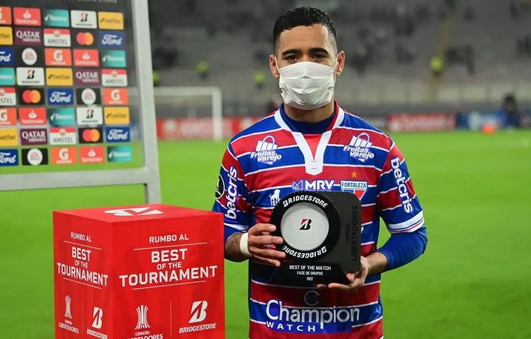 Imagem mostra homem segurando trofeu