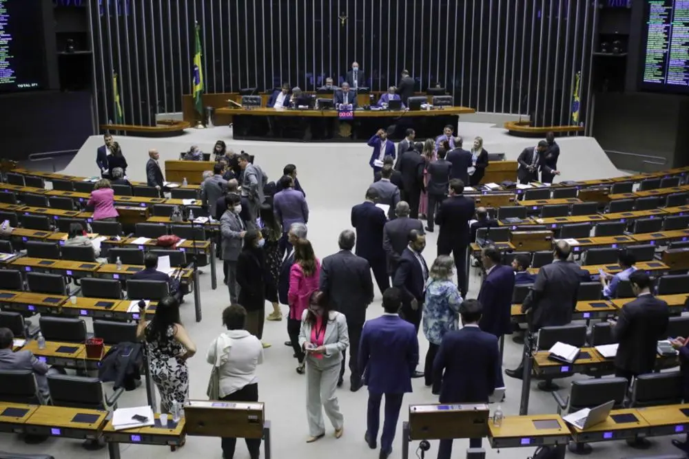 Sessão na Câmara dos Deputados. Imagem vista de cima, com vários parlamentares caminhando pelo plenário.