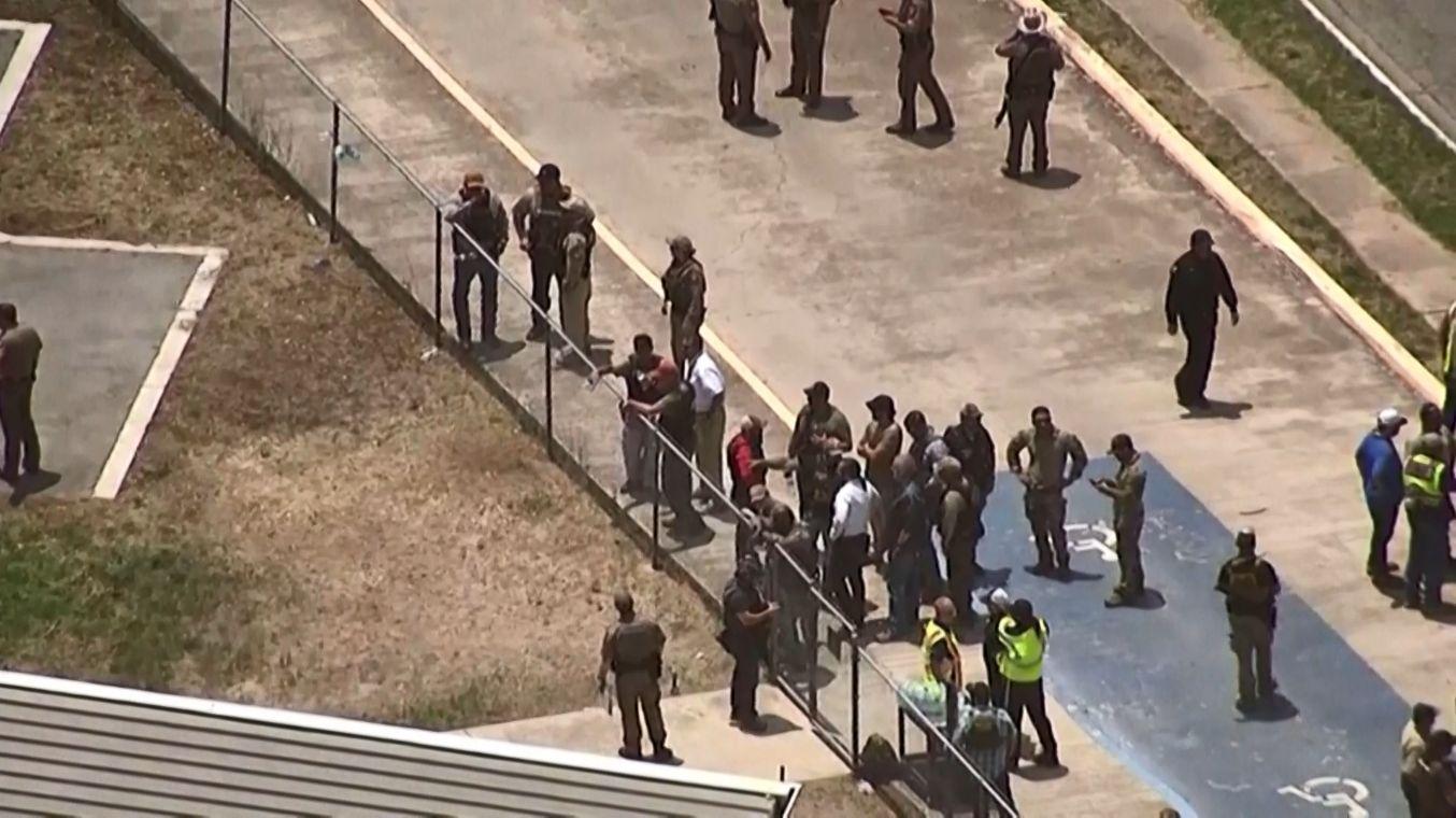policiais e pessoas do lado de fora de escola onde atirador matou 15 pessoas no Texas