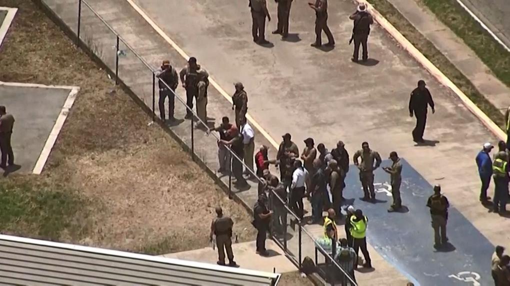policiais e pessoas do lado de fora de escola onde atirador matou 15 pessoas no Texas